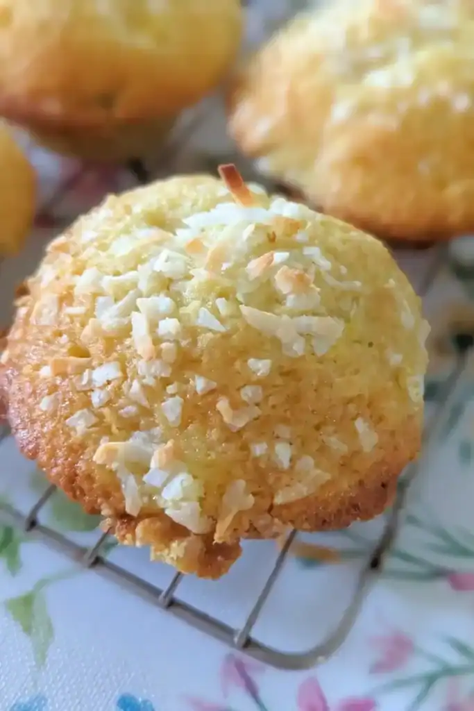 the top of a peach coconut muffin on the wire rack