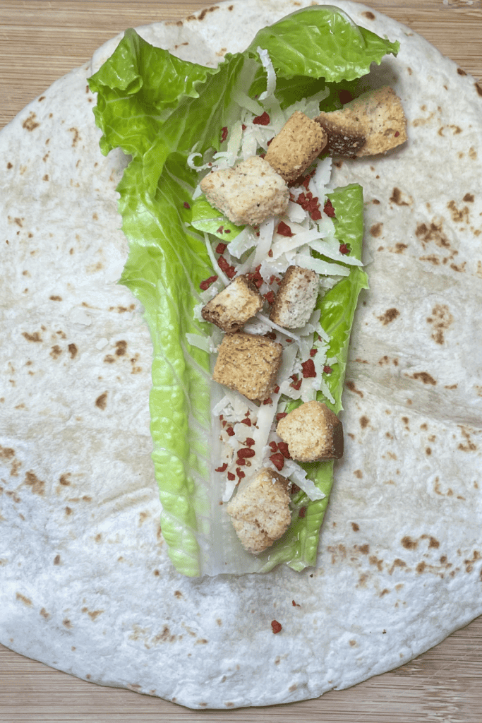 add bacon bits and croutons to Chicken Caesar sandwich wrap