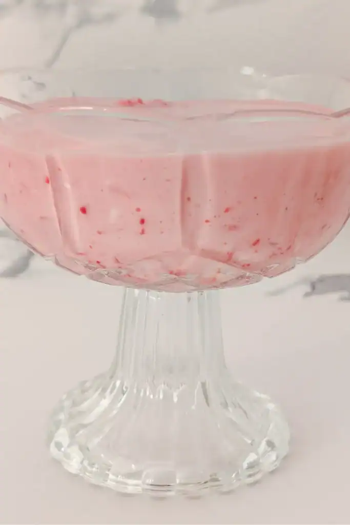 glass dessert cup with the no-bake raspberry cream cheese salad set in it