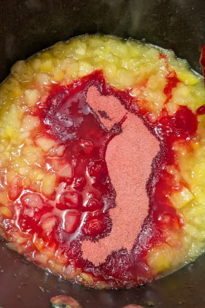heated pineapple sugar mixture adding jello powder in saucepan