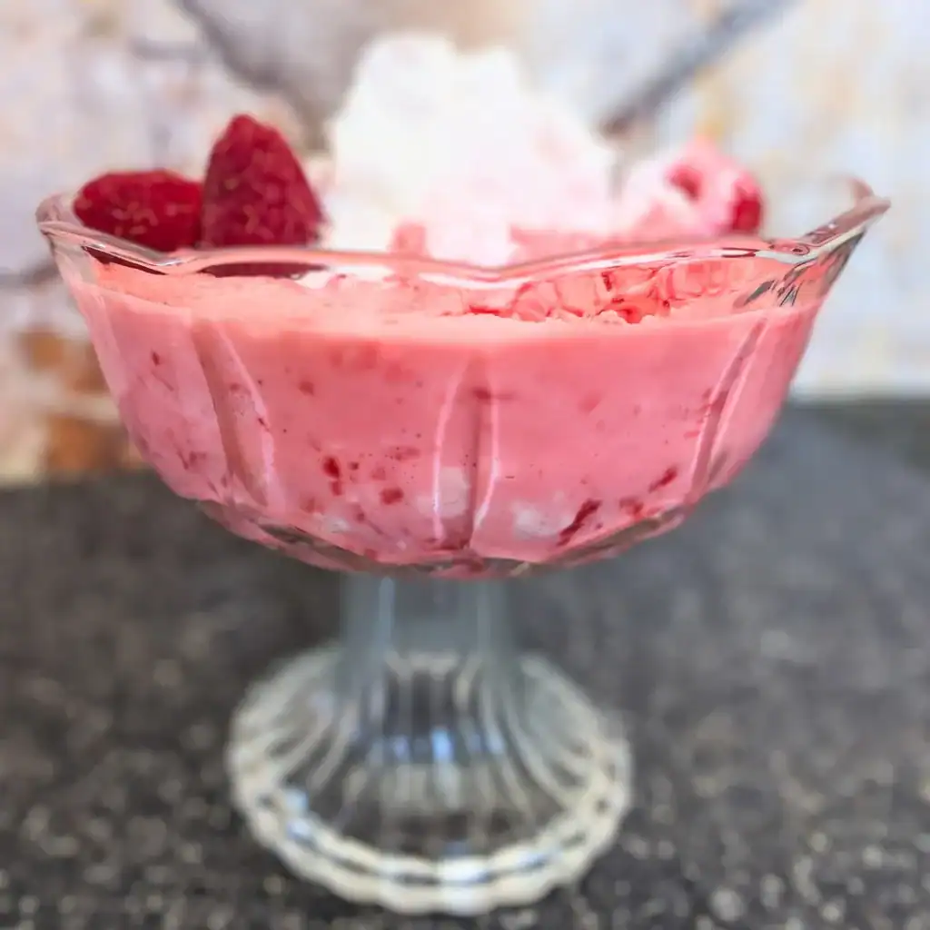 side view of dessert cup filled with the no-bake raspberry cream cheese salad 