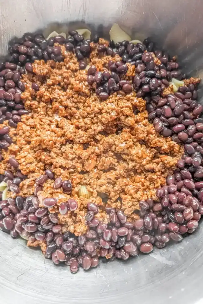 adding the drained black beans to taco salad