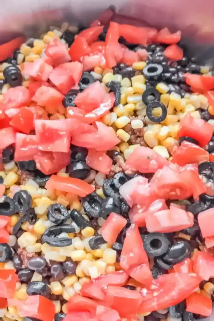 adding chopped tomatoes to taco salad