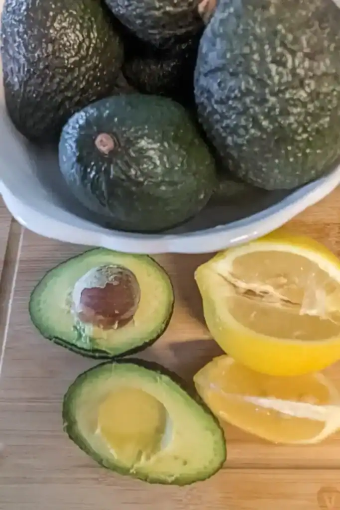 avocados in bowl with one open beside bowl