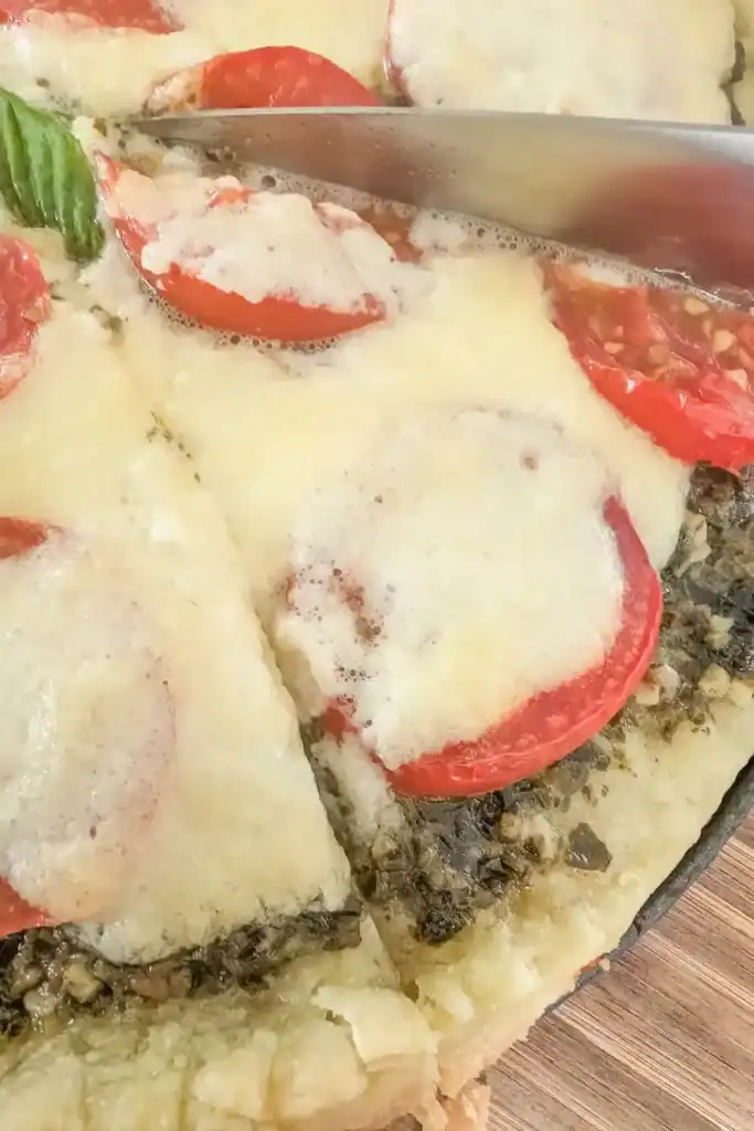 Cutting a piece close up from the baked tomato tart