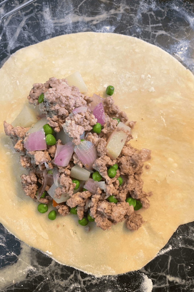 add ground beef and pork meat filling to pastry circle