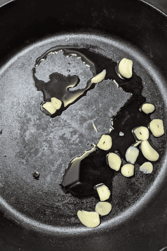 add olive oil and garlic to hot cast iron skillet