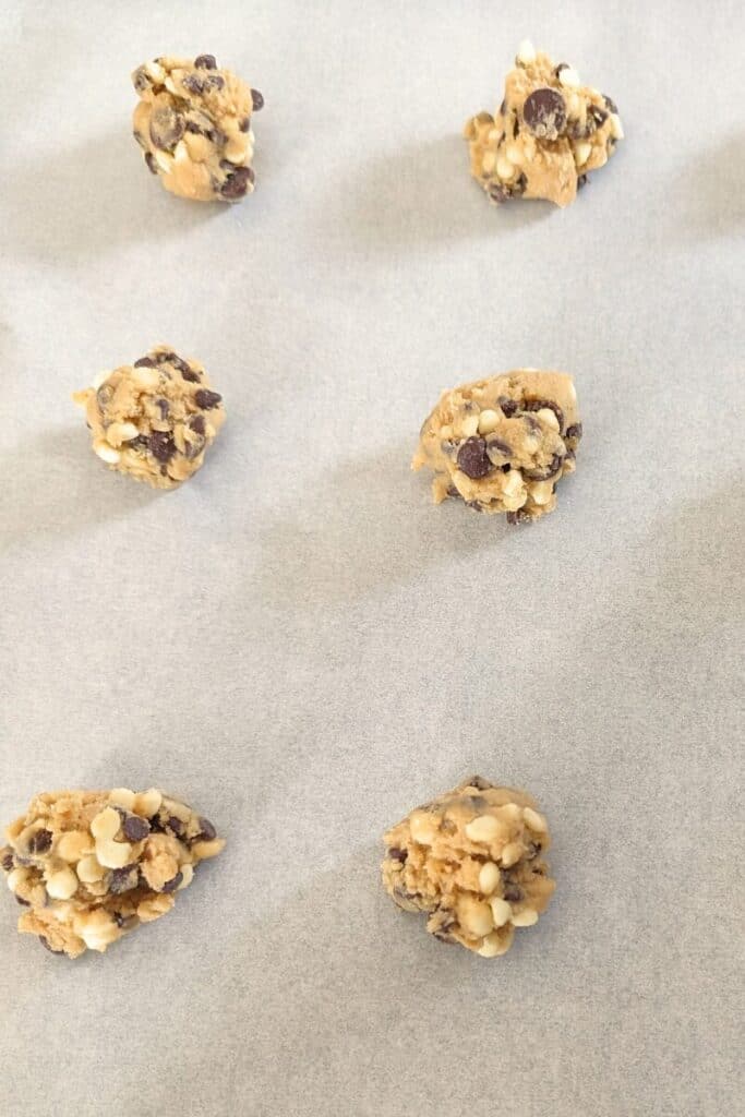 dropping cookie dough onto parchment paper