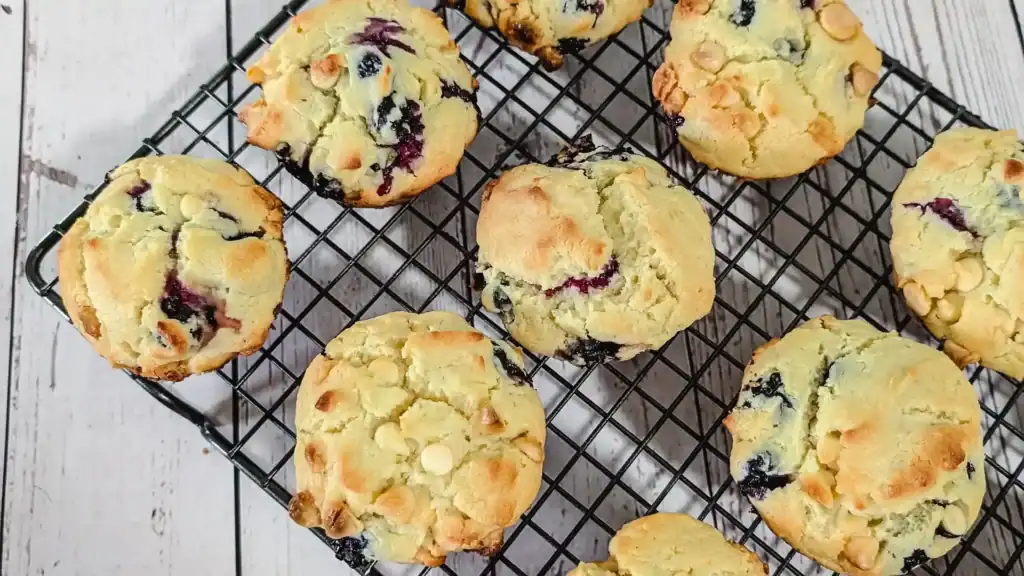 blueberry lemon cheesecake muffins with cream cheese baking chips cooling on grey wire baking rack