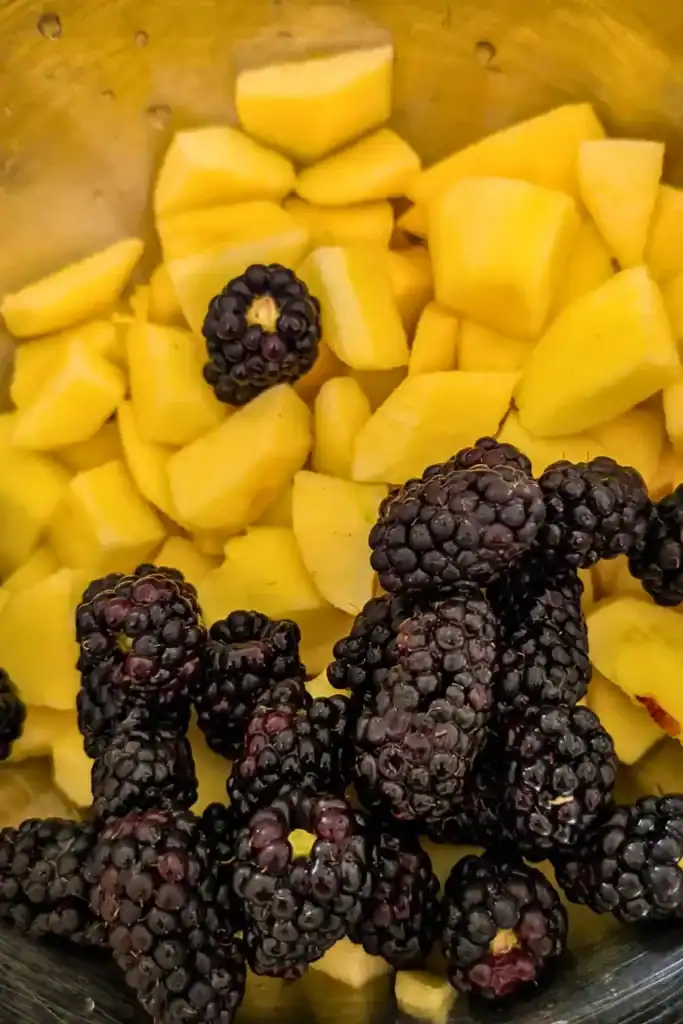 blackberries added to chopped apple in stainless steel bowl