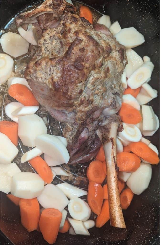 partially cooked leg of lamb and root vegetables