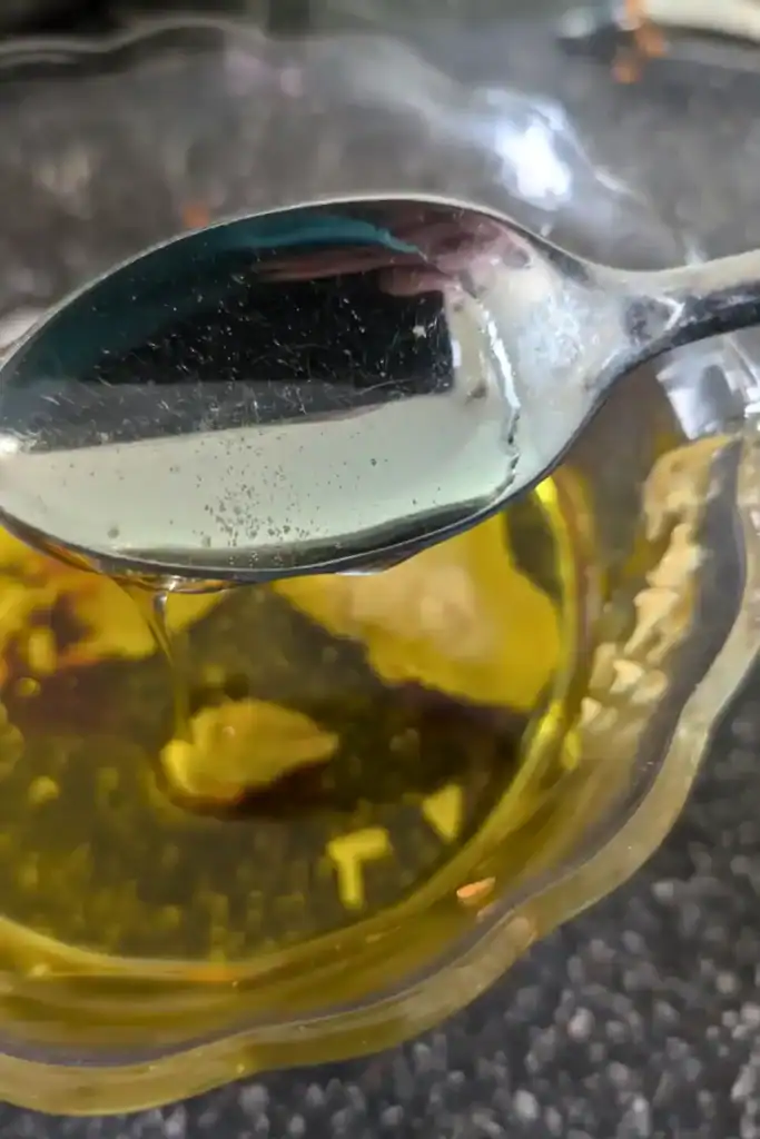 adding a spoonful of honey to the oil and garlic