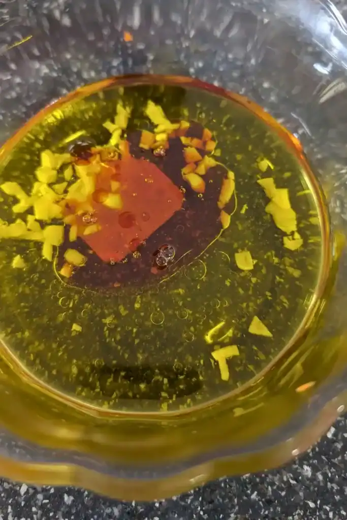 adding the red wine vinegar to the salad dressing