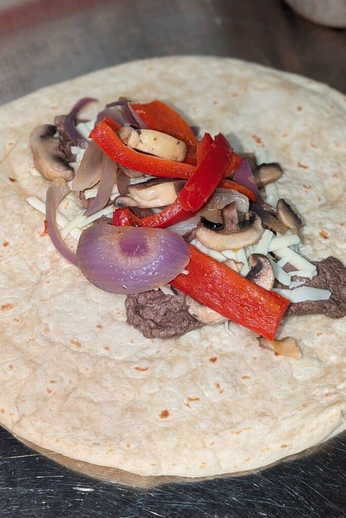 add the sauteed mushroom pepper mix to the wrap