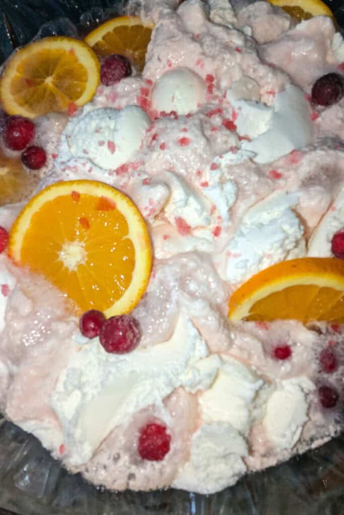 adding frozen cranberries to punch bowl