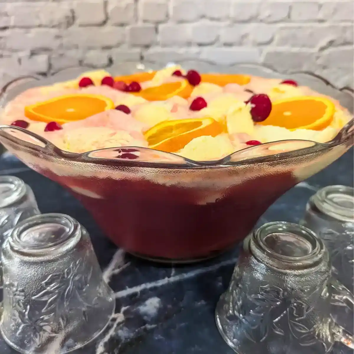 snowball christmas punch in glass punch bowl with upside down punch glasses on the table