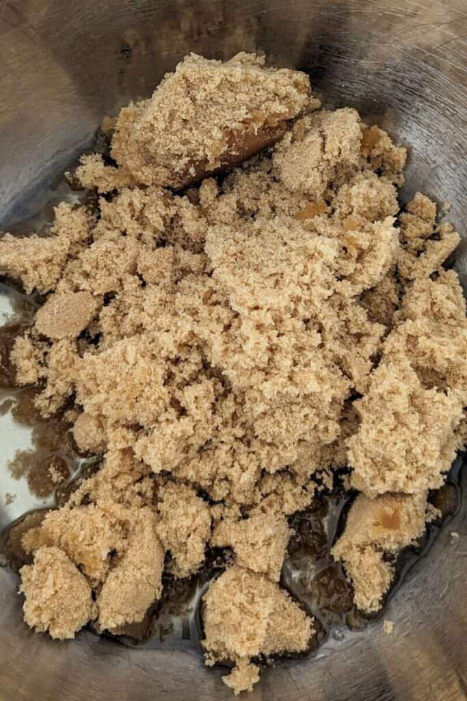 adding brown sugar and oil to mixing bowl