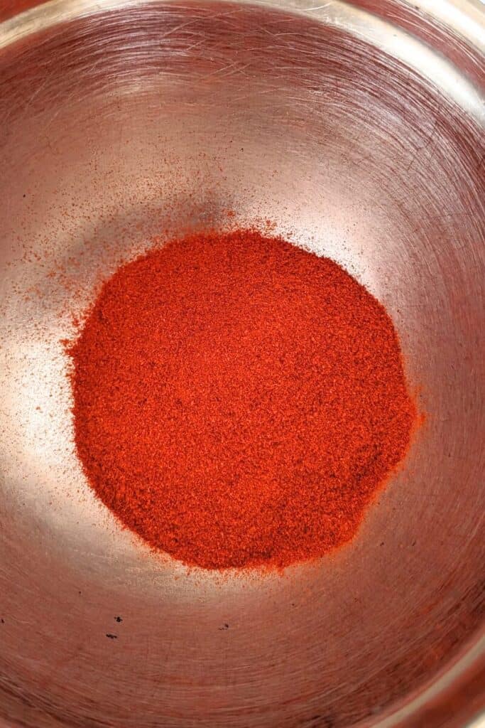 adding paprika to stainless steel bowl