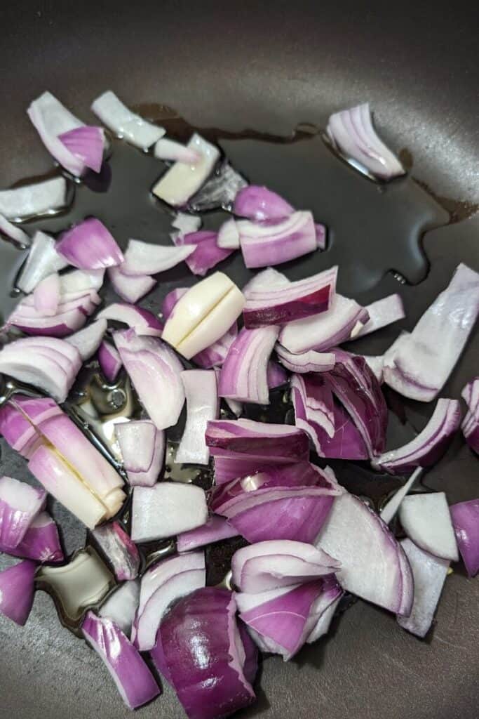 chopped red onion and olive oil in frying pan