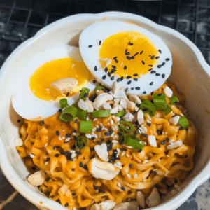 Delicious spicy peanut instant noodles topped with soft-boiled jammy eggs and chopped green onions.