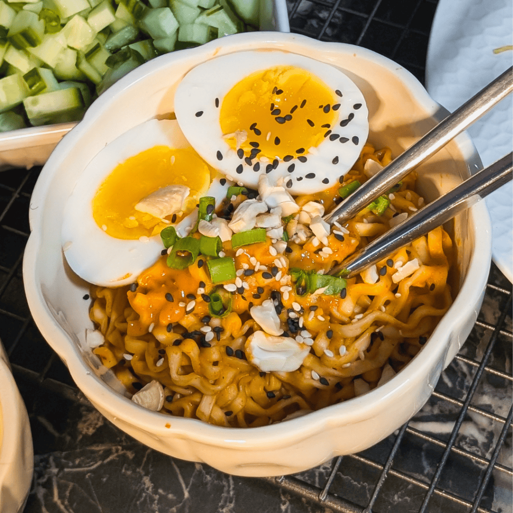Delicious spicy peanut instant noodles topped with soft-boiled jammy eggs and fresh green onions. Pe.
