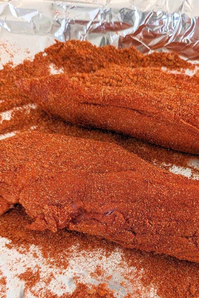 thoroughly coat pork tenderloin with dry rub