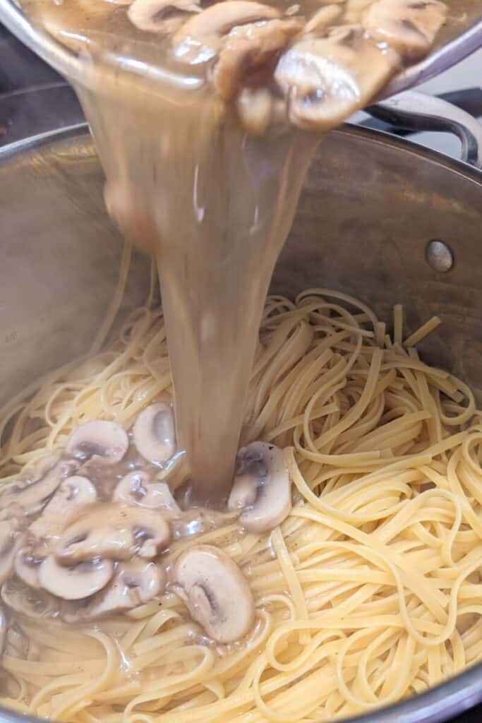 pouring thickened pasta sauce onto the Mushroom linguine 