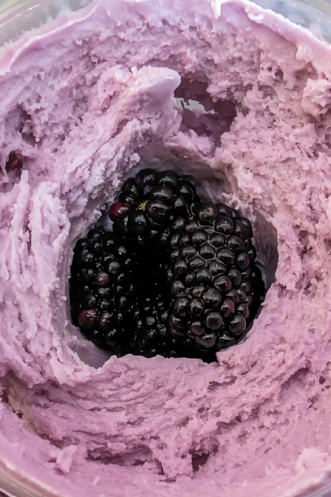 adding blackberries to hole in taro ice cream