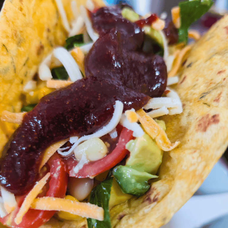 Delicious BBQ chicken wrap filled with fresh vegetables, cheese, and savory sauce, perfect for a qui.