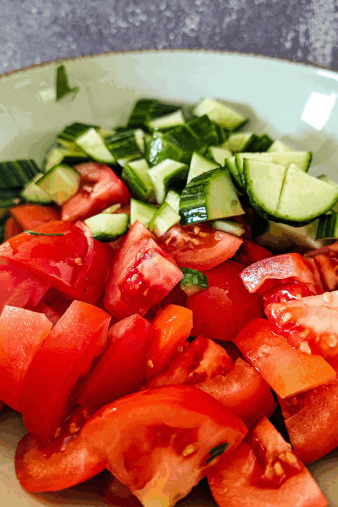 adding cucumber pieces to the salad