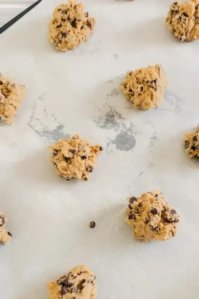 putting cookie balls onto baking sheet lined with paper