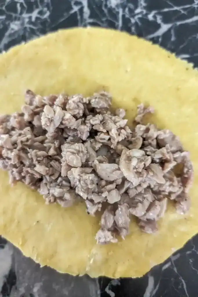 spooning the meat mixture on the patty round