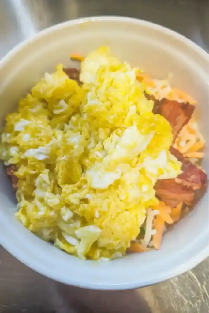 scrambled eggs added to cheese onion bacon
