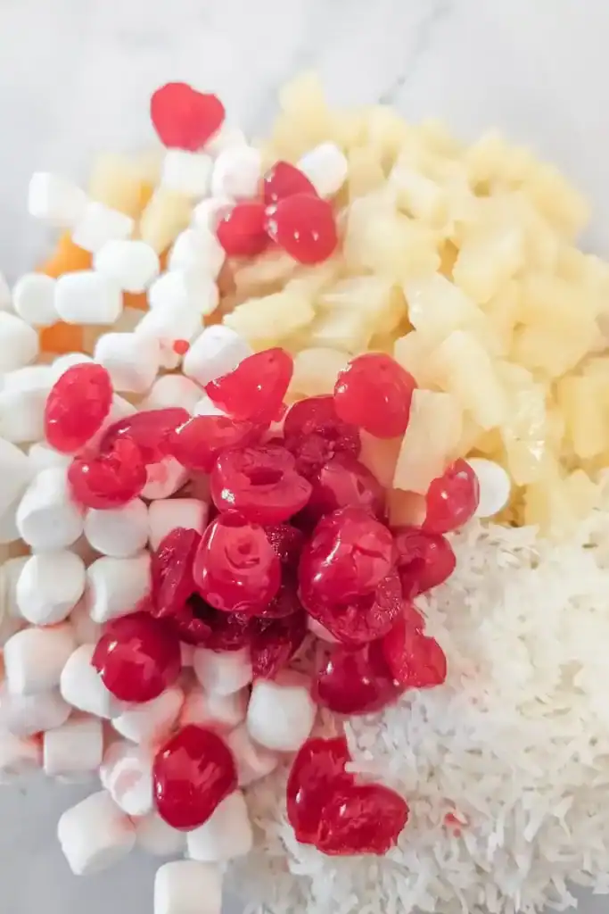 adding halved marschino cherries to salad bowl