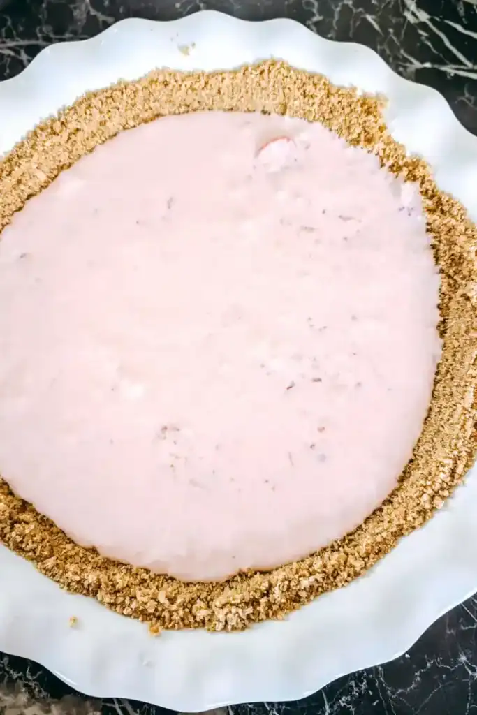adding strawberry pie filling to pie shell