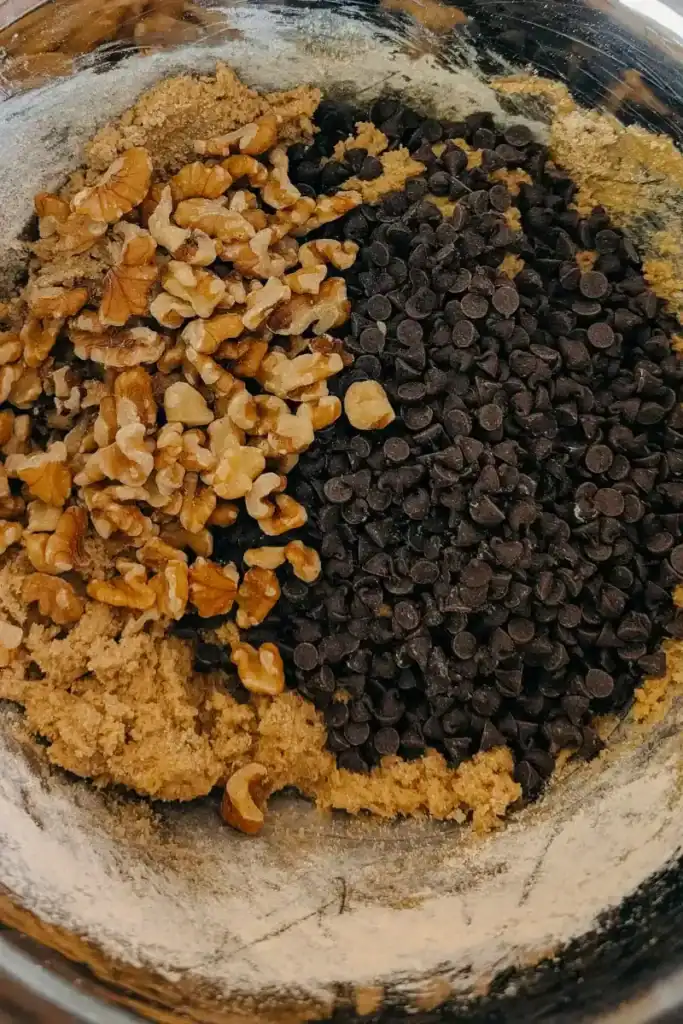 adding mini sweet chocolate chips and chopped walnuts to cookie dough