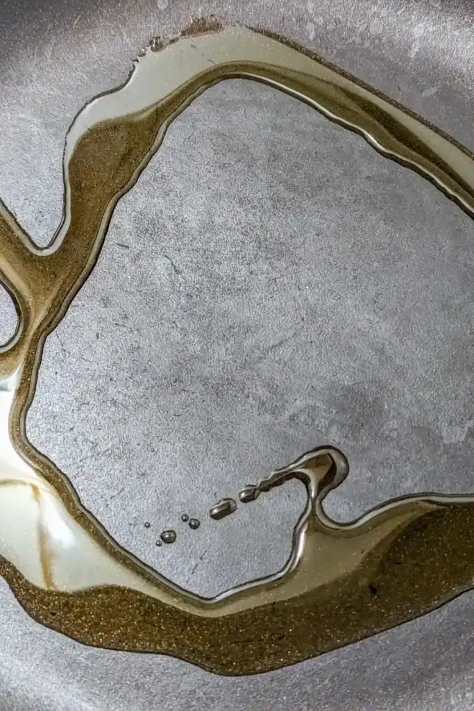 adding olive oil to frying pan