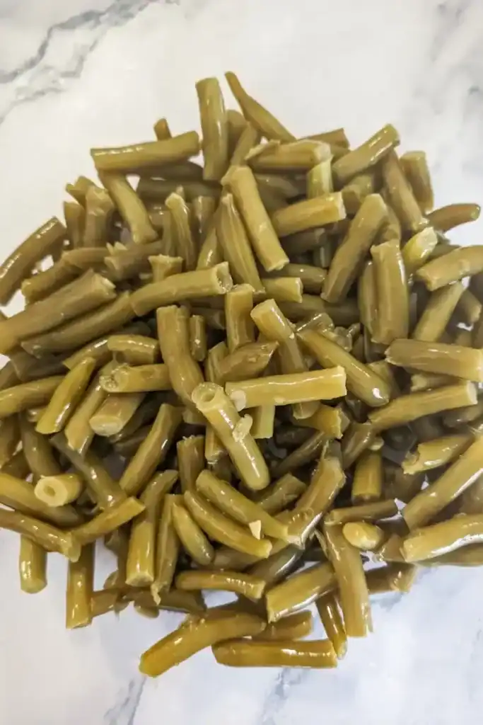 adding green beans to salad bowl