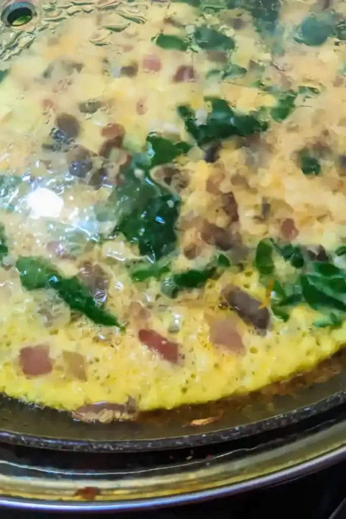 lidded frittata cooking on stovetop