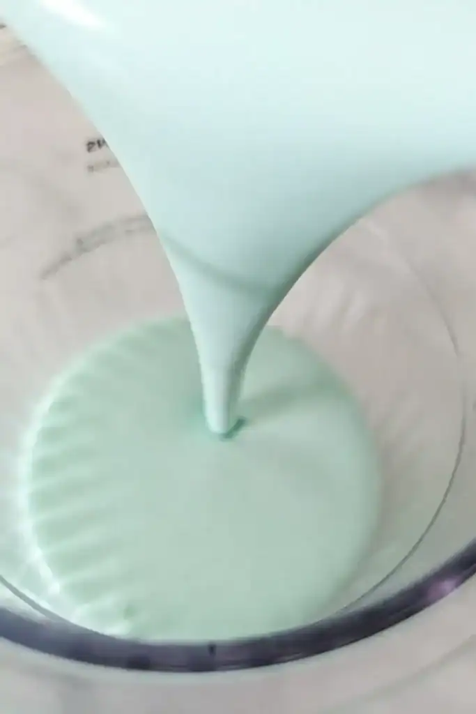 pouring the blue raspberry ice cream base into the pint container