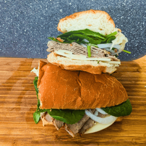 Submarine sandwich with roast beef, fresh vegetables, and bread.