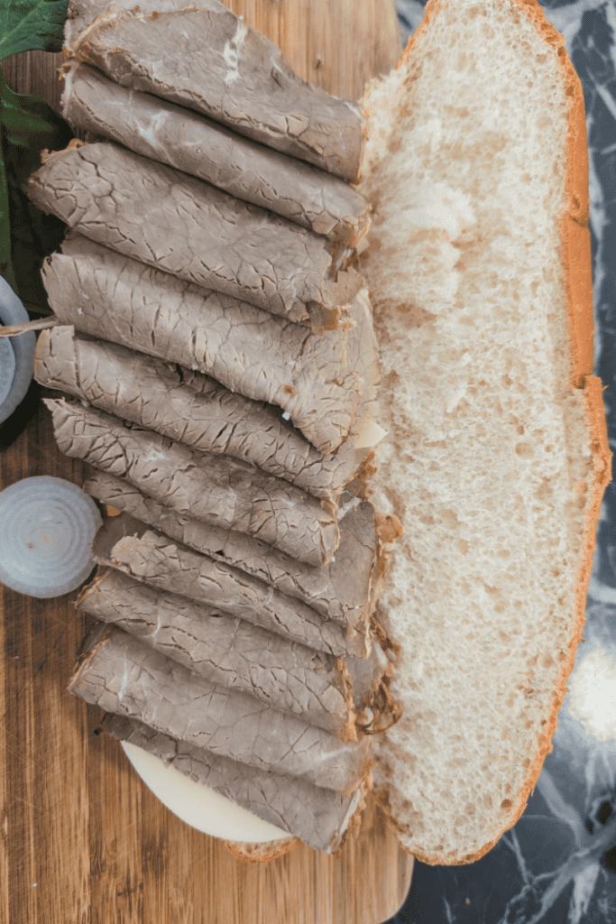Sliced roast beef on a sandwich bun for a submarine sandwich.