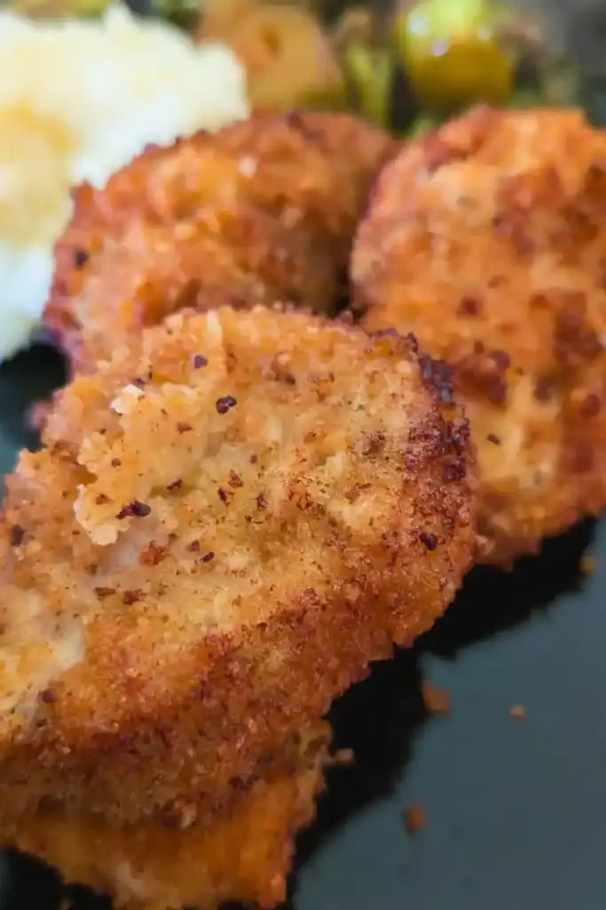 a trio of pork medallions on a plate with mashed potatoes