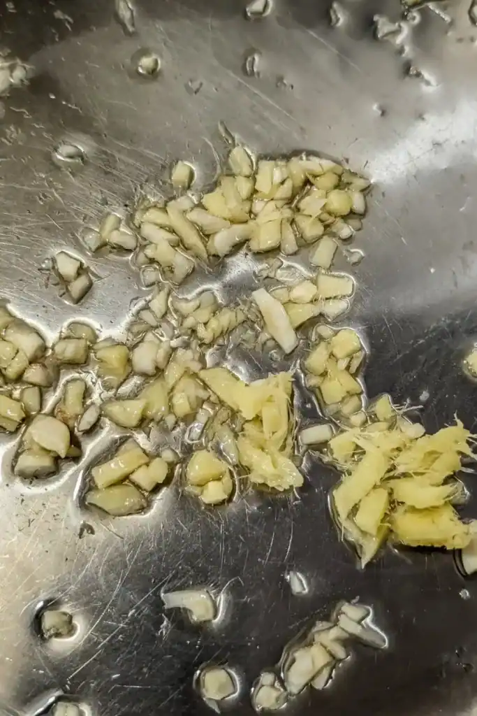sauteing aromatics ginger and garlic in stainless steel frying pan