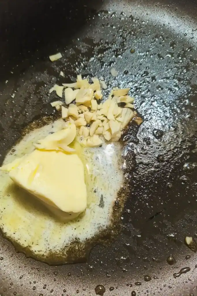 adding butter and garlic to mushroom pan