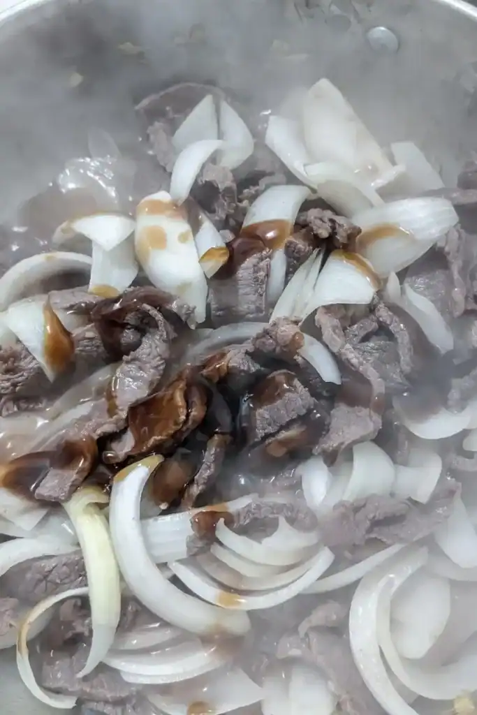 adding the sauce ingredients to the beef stir fry