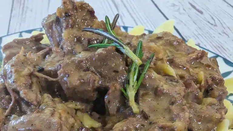 Rich Beefy Noodles with a sprig of rosemary on top