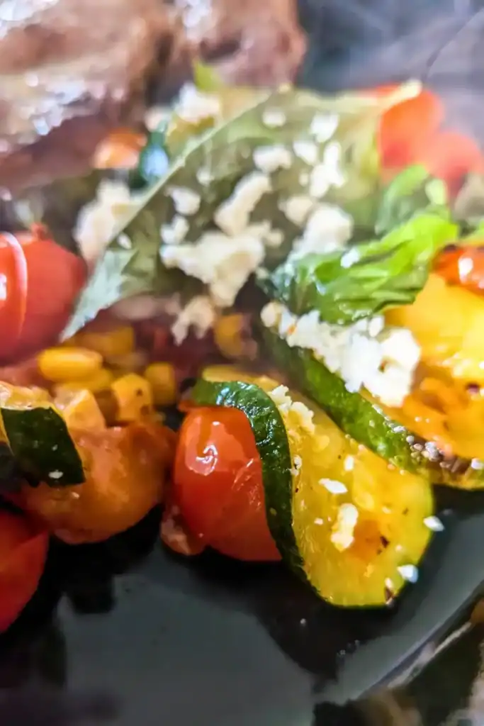 a close up of the zucchini sauted with tomato and corn