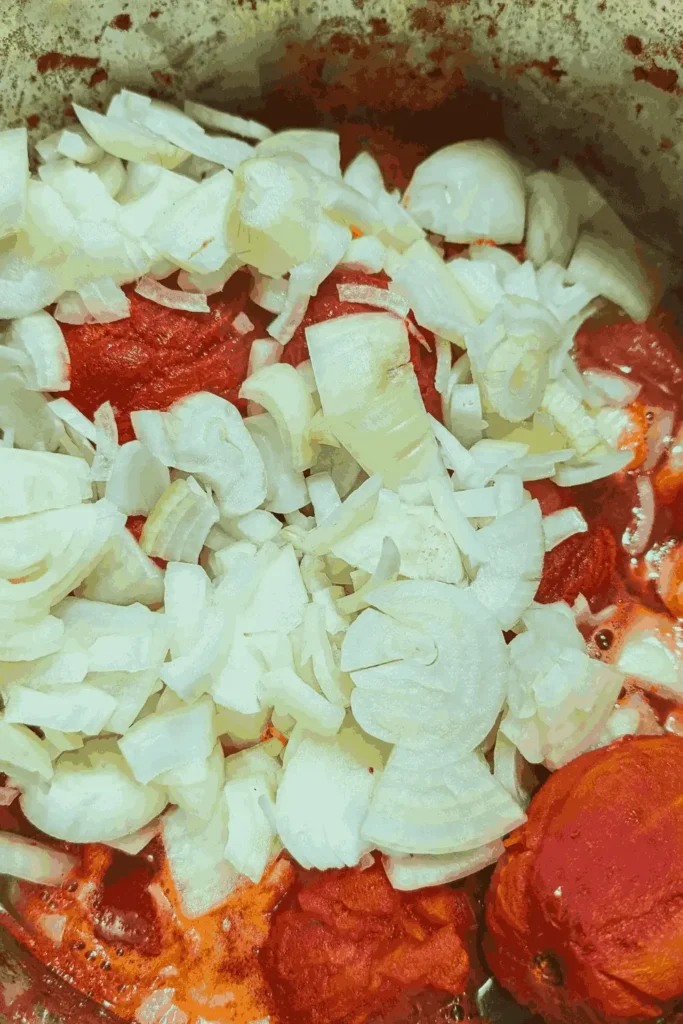 shredded chicken breast with buffalo sauce in stainless steel bowl