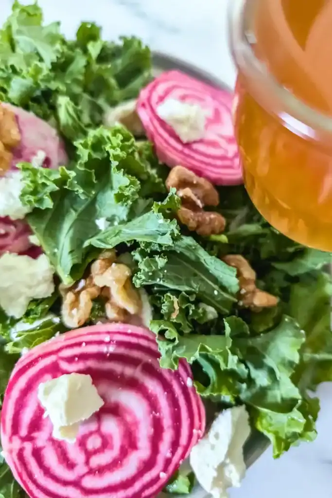 pouring the maple apple vinaigrette over salad